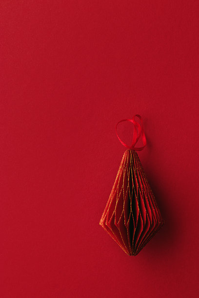 节日红色纸质圣诞装饰品，悬挂的红色手电筒或灯笼，红色背景上的蜂窝状斯堪的纳维亚装饰，简约单色照片，温暖的节日气氛，俯视图，空白空间图片下载