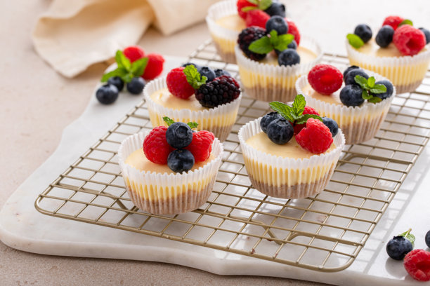 迷你芝士蛋糕，烤制在松饼模具中，上面装饰着新鲜浆果图片下载