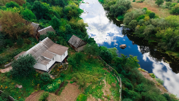 乡村小屋后院靠近河流，宁静的欧洲乡村地区，夏季晴朗的白天鸟瞰照片图片下载