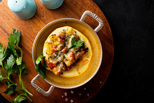 黑色背景上方视角的圆形西葫芦，烤制后填充肉末和奶酪，照片留有空白空间图片下载