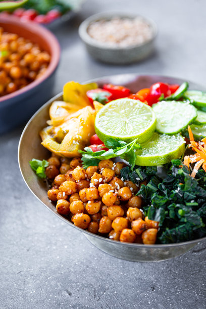 佛陀碗 - 桌子上摆放的素食碗，里面有鹰嘴豆和新鲜蔬菜的竖版照片图片下载