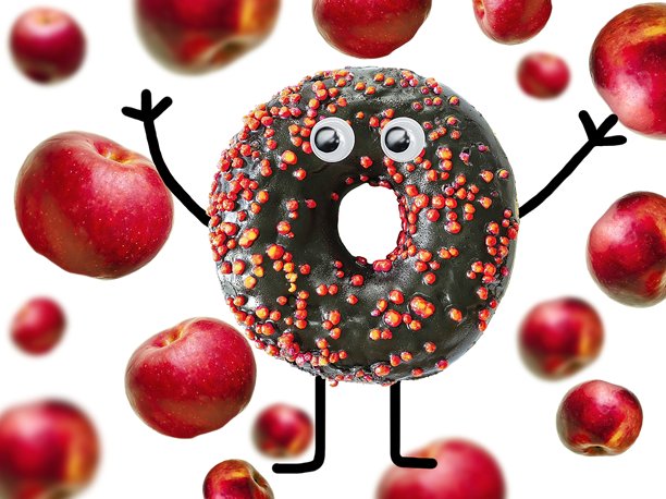 有趣的甜蜜糖霜甜甜圈，呈现怪兽面孔，周围漂浮着苹果。创意万圣节食品照片，俯视平铺的不健康垃圾甜点。图片下载