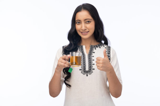 年轻女性在白色背景下喝绿茶的肖像照片图片下载