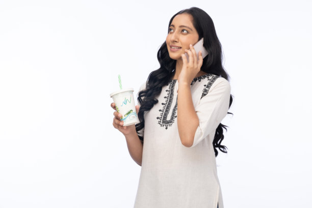 年轻女性在白色背景下喝青柠汁并使用手机的照片图片下载