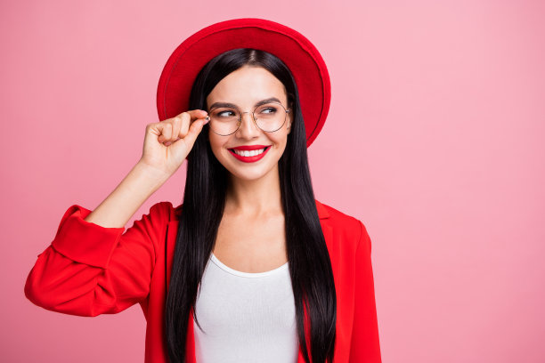 一位聪明的女性在粉色背景下，凝视空白处，轻触眼镜的照片肖像图片下载