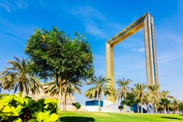 迪拜照片框。最大的金色照片框。人们在阿联酋迪拜扎比尔公园的建筑地标和高观景台旁走过。图片下载