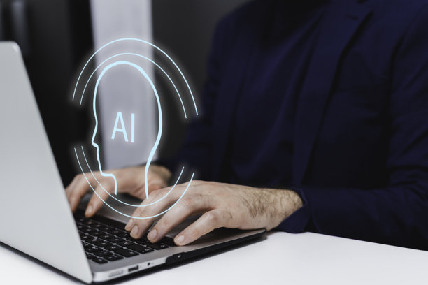 裁剪的图片显示一位商人在办公室的工作场所使用笔记本电脑打字。图片下载