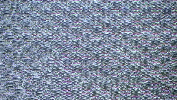 特写宏观照片，展示了一种闪闪发光、质感独特的金属光泽厨房清洁球，呈现出交织纤维的抽象图案和彩虹色彩。图片下载