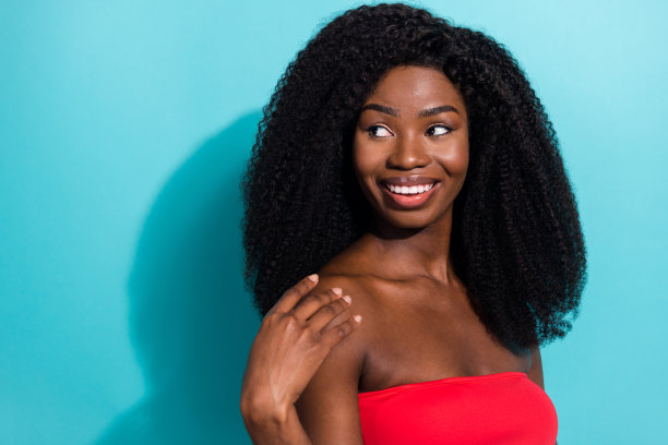 女孩在明亮的蓝色背景下微笑，表情好奇，面朝空白空间的照片肖像图片下载