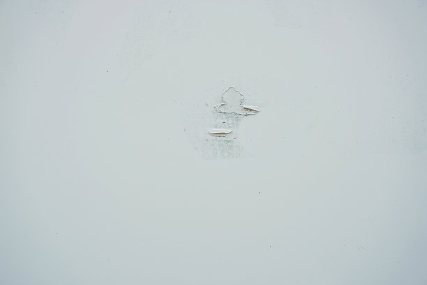 一面剥落油漆的旧白墙的表面或背景。潮湿发霉的房屋墙壁照片。图片下载