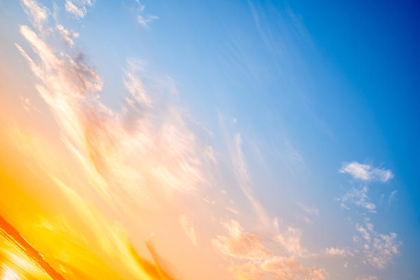 美丽奢华的柔和渐变橙金色云彩和阳光映照在蓝天上，完美适合作为背景，拍摄于傍晚黄昏，大尺寸高清风景照片图片下载