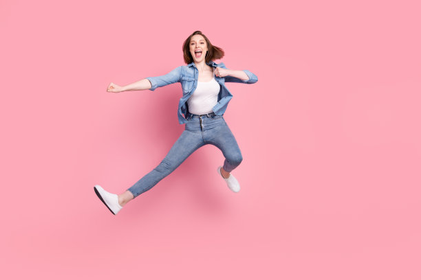 女孩在粉色背景下跳跃练习空手道的全身照片图片下载