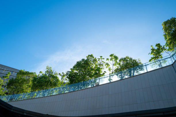 现代建筑外立面，顶部有垂直绿化和树木图片下载