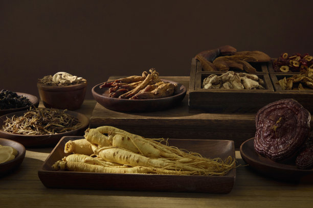 人参根部的俯视照片，周围环绕着东方药材，放置在木桌上。经典的草药疗愈成分自然呈现。传统医学有益健康。图片下载