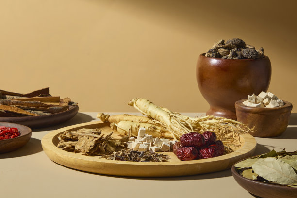 美丽地排列着的干人参根放在一个圆形托盘上，旁边有枸杞、干果和一个陶瓷罐，散发出温暖和自然健康的气息。正面视角，广告照片。图片下载