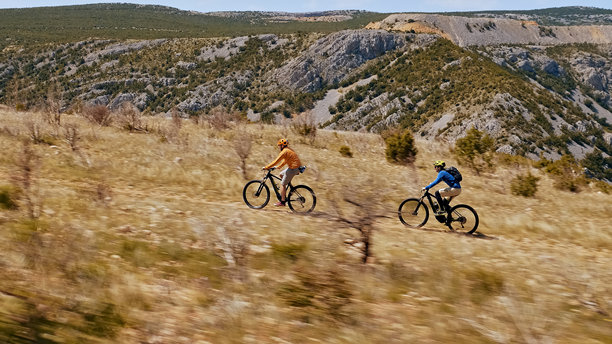 两名骑自行车的人在越野骑行，享受山地自行车带来的自由刺激。图片下载