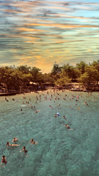 在一次船游中拍摄的岛屿照片，岛上有一个人们游泳的海滩。图片下载