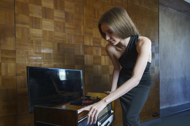 复古浪漫照片，年轻女性在播放黑胶唱片，复古音乐，浪漫的幽静夜晚图片下载