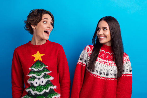 两位积极的女孩在蓝色背景下享受传统圣诞折扣的照片图片下载