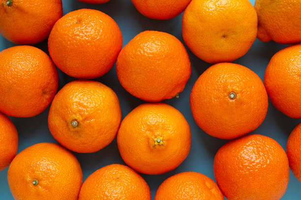 新鲜橙子的俯视图。生动的横向照片，展示了柑橘类水果的平铺背景。维生素C图片下载