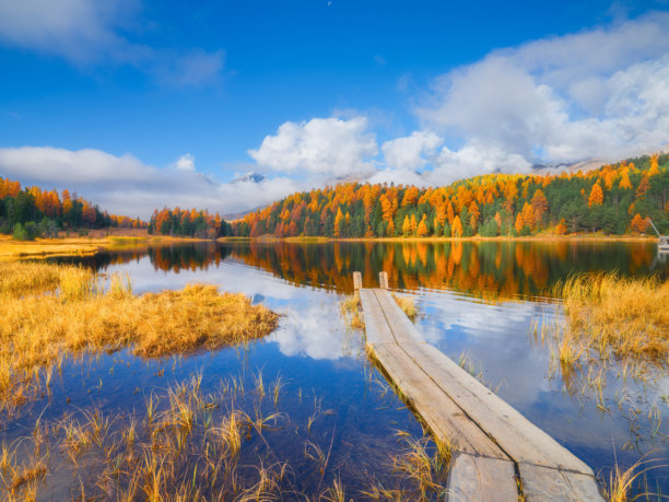 湖泊和小码头。瑞士的秋季风景。云朵和秋季森林。山谷与湖泊的惊人景色。适合用作背景、壁纸和明信片的照片。图片下载