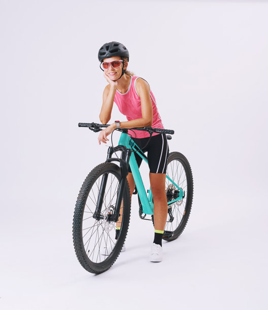 年轻女性穿着专业运动服，坐在山地自行车上，背景为白色。图片下载