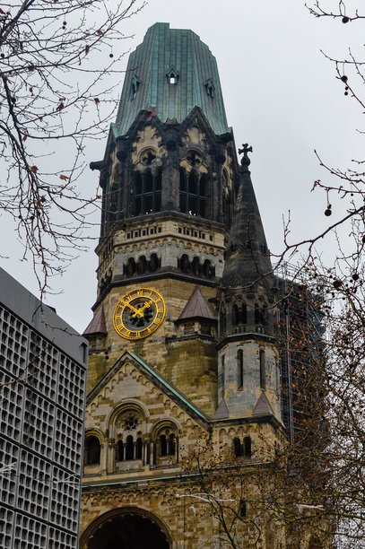 德国柏林的凯泽威廉纪念教堂照片，展示了历史悠久的受损钟楼及其哥特式细节，是战争历史和记忆的地标象征。图片下载