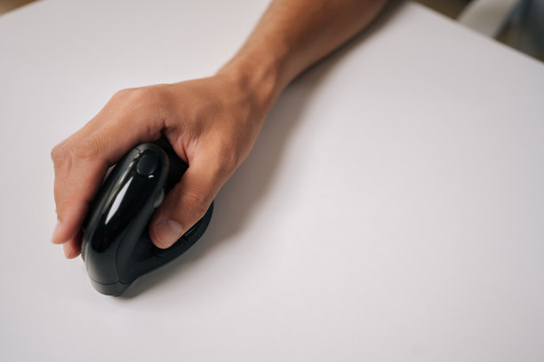 男性手握垂直人体工学鼠标的特写剪裁照片，背景为白色，突出设计并促进舒适的工作电脑使用。图片下载
