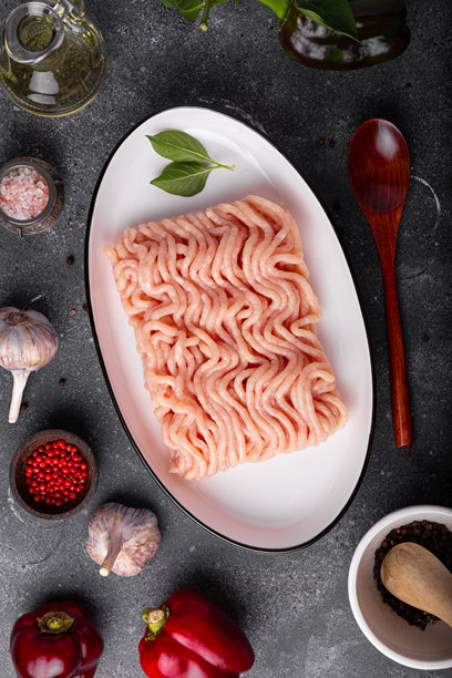 生鸡肉剁碎肉和配料。灰色背景上的垂直照片，俯视图展示了带有配料的剁碎肉。图片下载