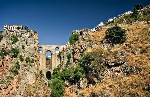 西班牙安达卢西亚小镇隆达的“新桥”历史彩色照片，石拱桥和地标，背景是陡峭的悬崖，天气晴朗，照片拍摄于2001年5月23日。图片下载