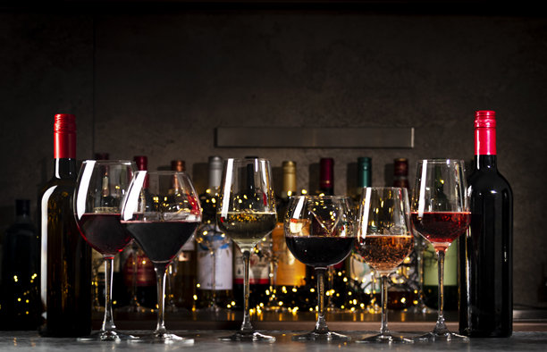 酒杯中的葡萄酒。红酒、白酒和玫瑰酒在黑色背景下与酒瓶搭配。酒吧、商店、品酒或 degustation。图片下载