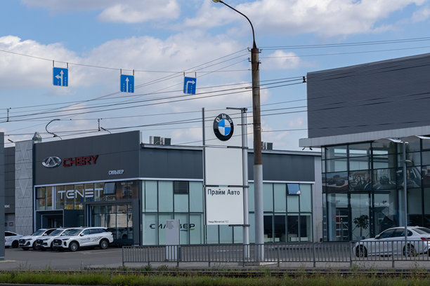 宝马和奇瑞汽车经销商在繁忙的街道上显眼展示，展示现代汽车品牌和充满活力的标识，位于商业区。图片下载