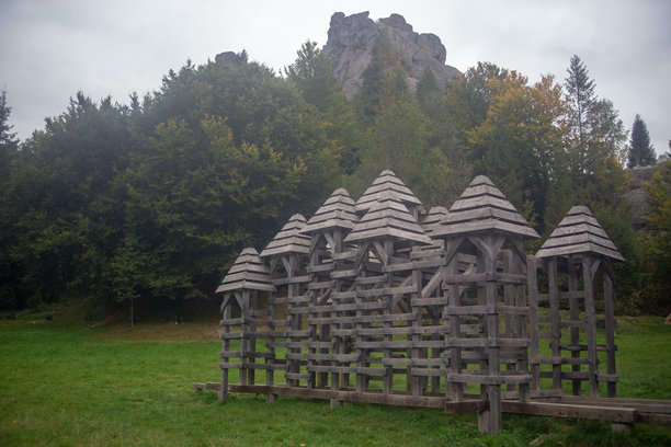 这张照片展示了一件木质建筑作品，背景是令人惊叹的自然景观。图片下载