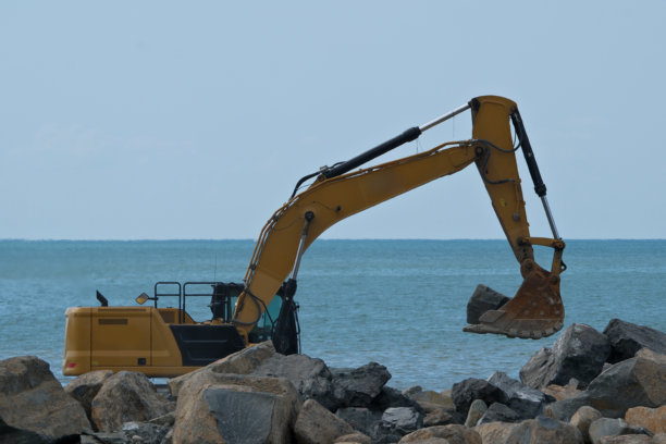 夏日海岸边的挖掘机在工作。海岸边的挖掘机，特写照片。图片下载