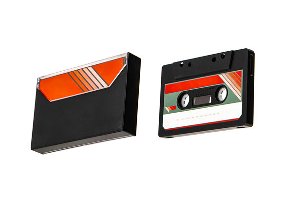 一盘紧凑型卡带及其外壳，带有复古风格的条纹标签。图片下载