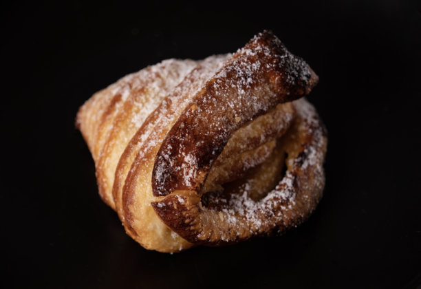 甜美酥脆的可颂面包配果酱，撒上萨扎粉，放在黑色玻璃上，暗调照片图片下载