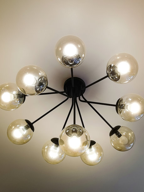 现代吊灯配有圆形玻璃灯罩，悬挂在天花板上。特写，竖版照片。图片下载