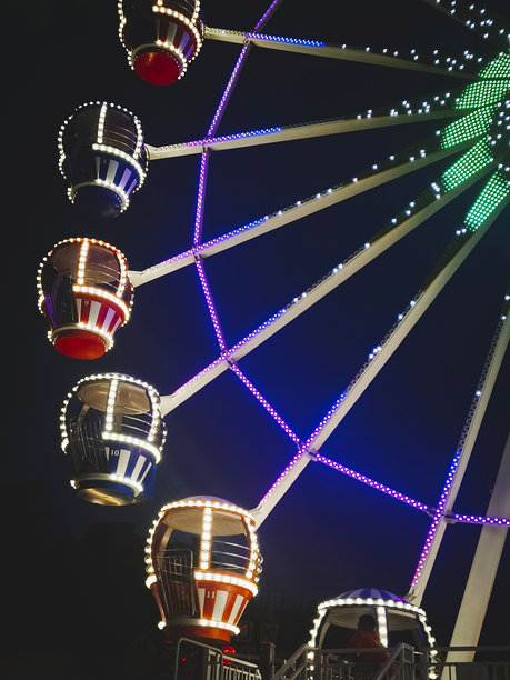 游乐园中的摩天轮。美丽的夜景与灯光照明。竖版照片。图片下载