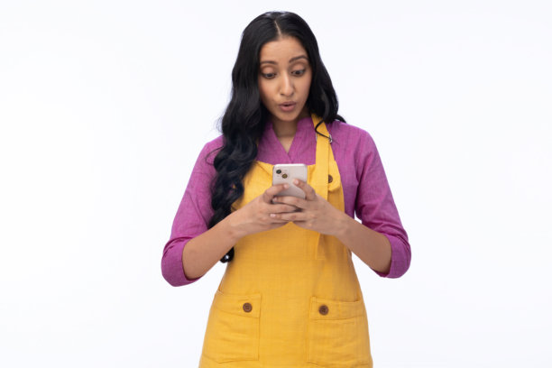 年轻女厨师在白色背景下使用手机的肖像照片图片下载