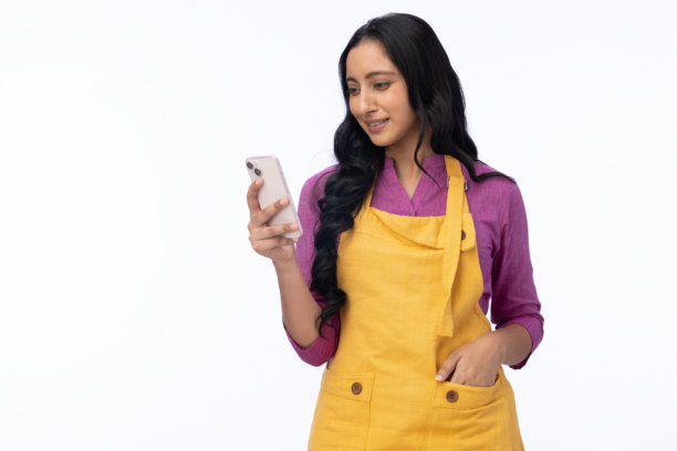 年轻女厨师在白色背景下使用手机的肖像照片图片下载