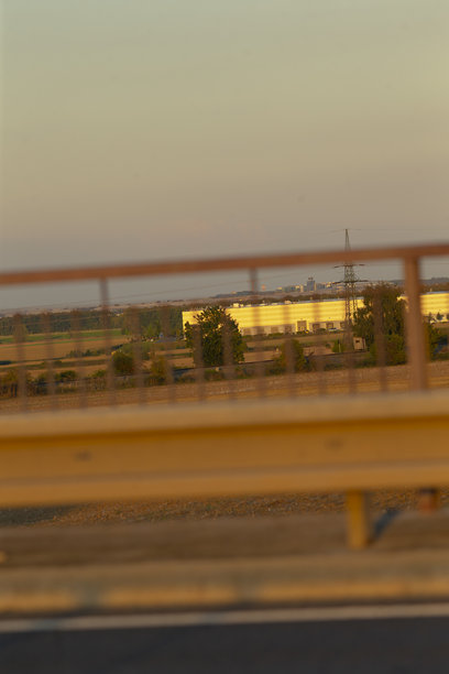 一张模糊的照片显示了日落时分一座桥横跨高速公路。图片下载