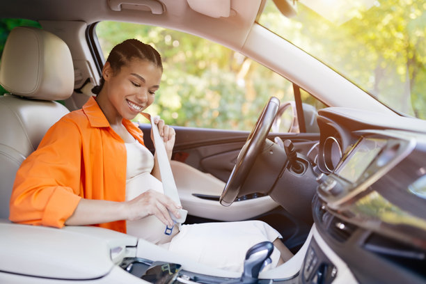 微笑着在车里系安全带的非裔美国孕妇图片下载