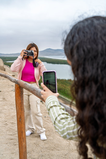 游客在沙漠中拍摄前印加遗址和泻湖的照片图片下载