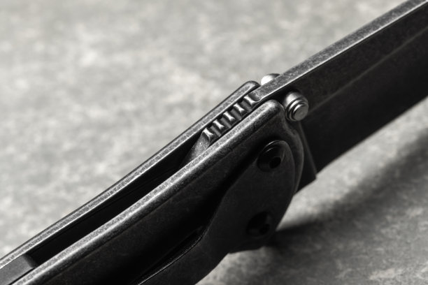 现代黑色折叠刀的细致宏观照片，带有纹理手柄图片下载