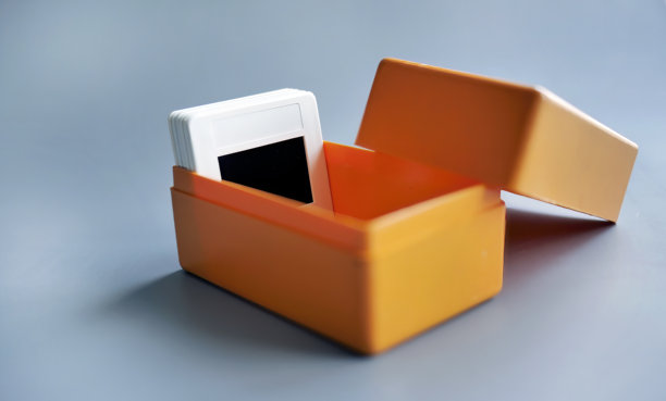 白色塑料幻灯片框架，装在橙色塑料盒中，背景简单，复古怀旧，照片图片下载