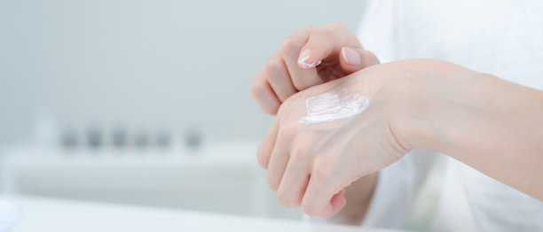 健康女性使用护肤霜。健康女性的面部涂抹护肤霜和化妆品。护肤霜广告，抗皱，婴儿般的面容，美白，保湿。图片下载