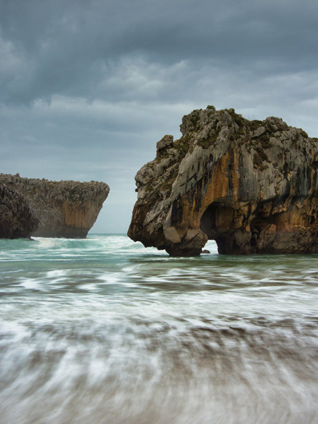阿斯图里亚斯崎岖的海岸悬崖和波浪 - 一张长时间曝光的照片，展示了西班牙阿斯图里亚斯的戏剧性海堆和海岸线，拍摄于阴云密布的日子。图片下载