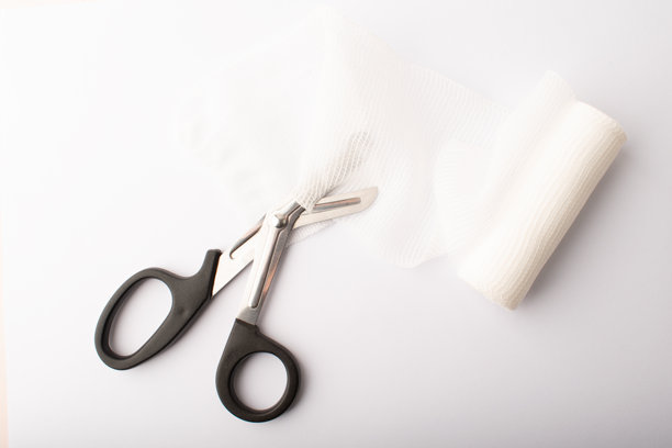 白色背景上从上方视角看剪刀剪断绷带。伤口处理。将创可贴贴在骨折处。医疗概念横幅。留白。高质量照片。图片下载