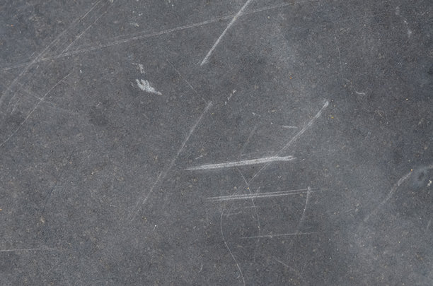 这张详细的照片捕捉了深灰色纹理的不完美，表面布满了许多划痕和磨损，传达出一种历史感和衰败感。图片下载