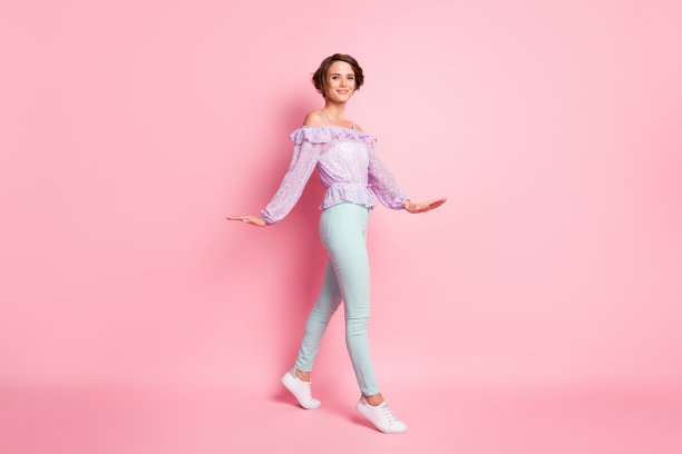 可爱女孩在粉色背景上行走的全身肖像照片图片下载